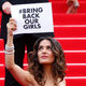 Actress and producer Salma Hayek holds a placard